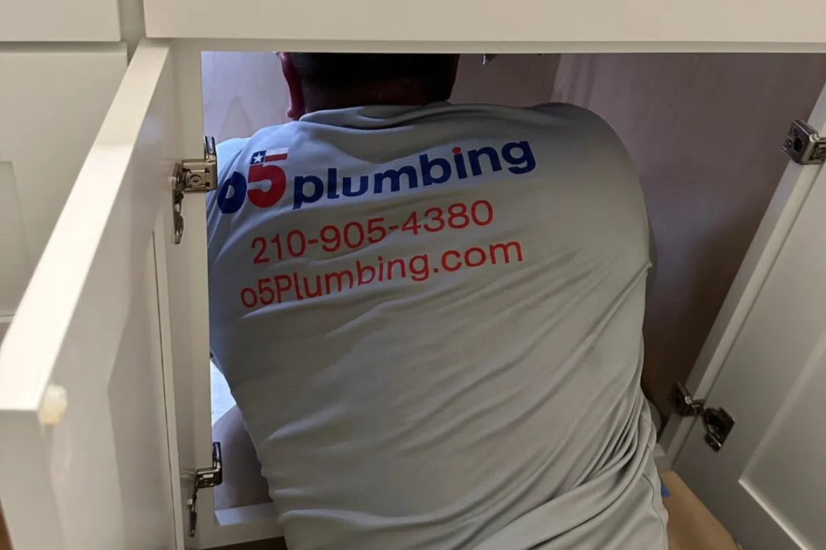 Expert Drain Cleaning Services in San Antonio: Ensuring Your Pipes are Perfect 2 Technician from 05 Plumbing working under a sink.