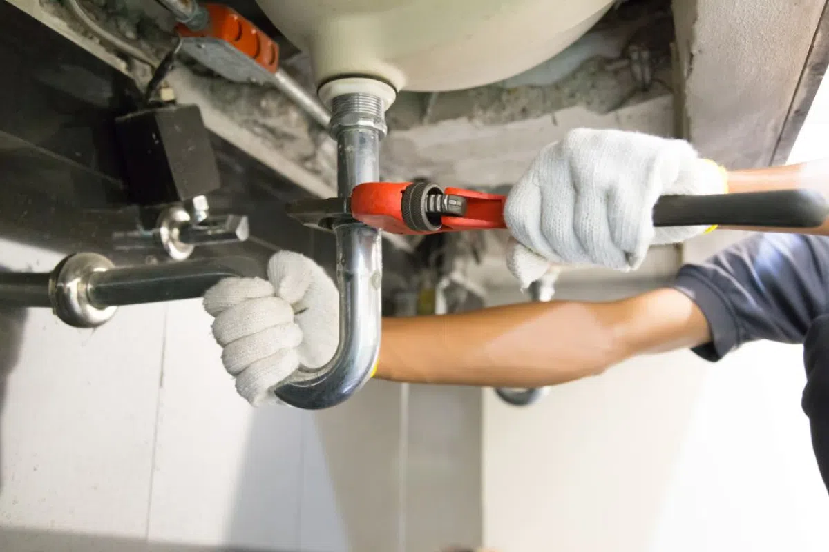 Expert Drain Cleaning Services in San Antonio: Ensuring Your Pipes are Perfect 3 Plumber tightening pipe with wrench.