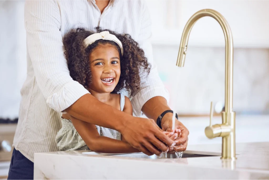 Parent and child washing hands together.