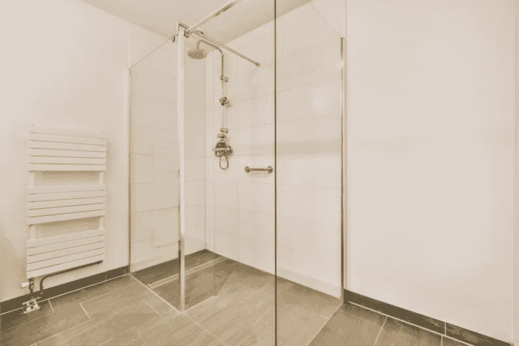 Shower & Bathtub Installation in San Antonio, Texas 24 A modern walk-in shower with glass doors and sleek tile flooring in a minimalist bathroom.