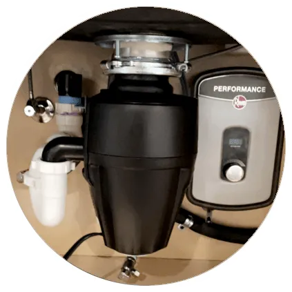 Under-sink installation featuring a black garbage disposal unit next to a gray Performance water heater.